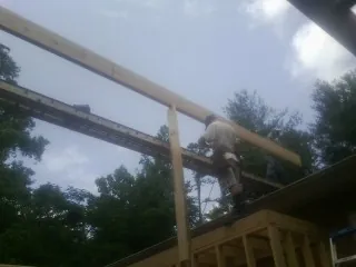 Carpenter setting a ridge beam over a new addition frame — Ice Dam Removal by Roofing Brothers in Milton Freewater