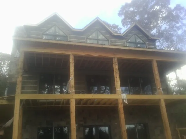 Dormers and porch framing on a large log home under construction — Roof Coating work by our crew in Milton Freewater