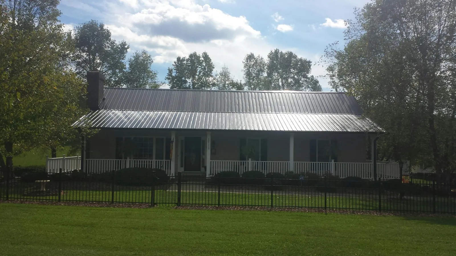 Gray metal roof on a brick ranch with a full width front porch — Gutter Guard Installation work by our crew in Milton Freewater