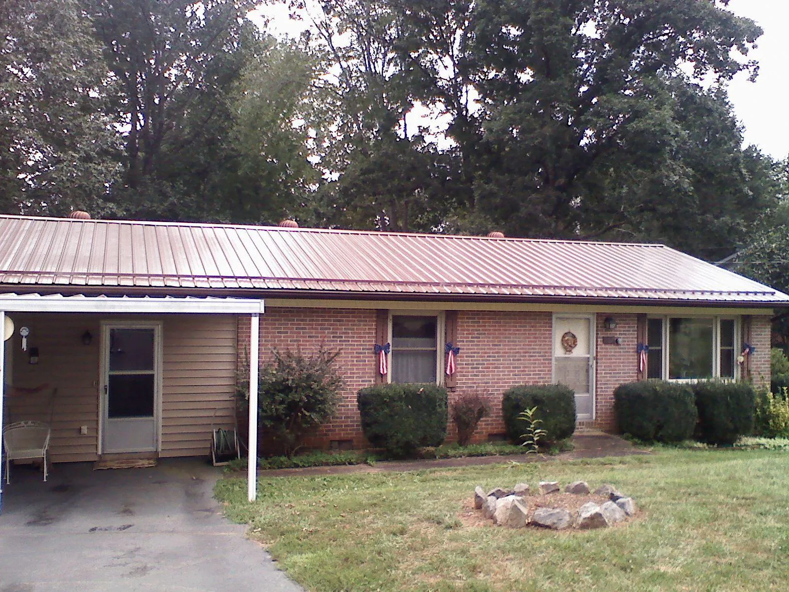 Bronze metal roof and carport on a brick ranch home — Roof Repair work by our crew in Milton Freewater